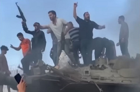 <p>Militantes palestinos sobre un tanque israelí en llamas durante el ataque de Hamás del 7 de octubre. /<strong> The Sun (Youtube)</strong></p>