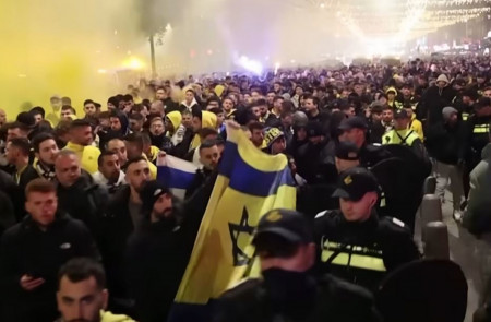 <p>Hooligans del Maccabi de Tel Aviv en Ámsterdam vigilados por la policía. / <strong>Michel van Bergen (Guardian News / Youtube)</strong></p>