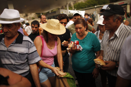 Agricultores temporeros y militantes del Sindicato Andaluz de Trabajadores (SAT) descansan para comer, durante la marcha organizada por el alcalde de Marinaleda en protesta por las reformas del Gobierno, en agosto de 2012. (photo: JON NAZCA)