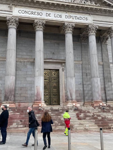 <p>La fachada del Congreso manchada de agua del color de la remolacha tras una protesta de Rebelión Científica. / <strong>CTXT</strong></p>