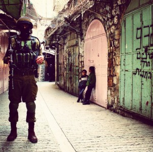 <p>Un soldado israelí junto a dos niños palestinos en una calle de Hebrón. Diciembre de 2014.</p>
