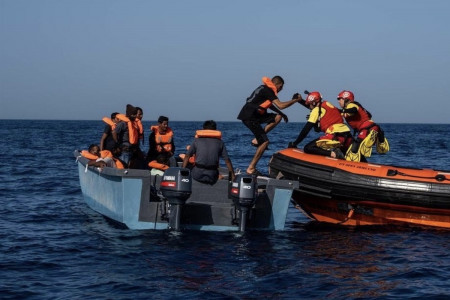 <p>Eduardo Blasco y una compañera del equipo de rescate ayudan a un migrante a subir a su balsa. / <strong>Cedida por el entrevistado</strong></p>