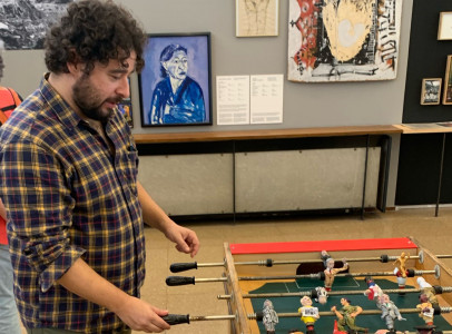 <p>Germán Labrador, comisario de la muestra, jugando con un futbolín  rojinegro, inspirado en las rivalidades entre anarquistas y comunistas. /<strong> P. C. </strong></p>