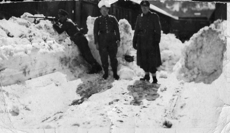 El guardia civil Antonio Benedé apuntando con el fusil junto a dos soldados alemanes en la estación de Canfranc en 1943.