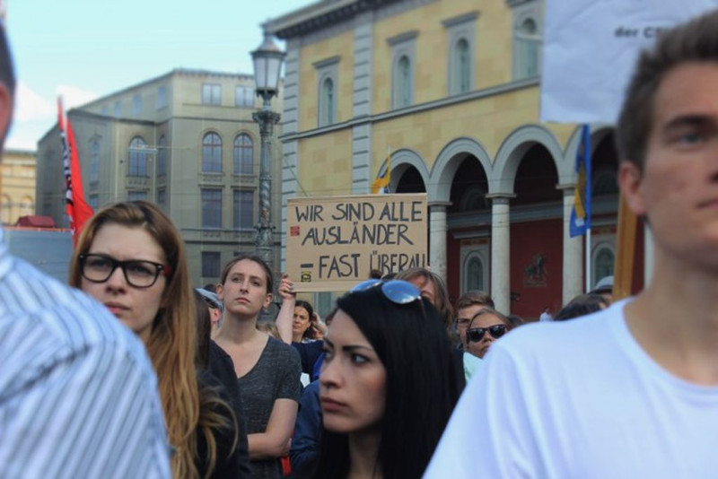 <p>'Todos somos extranjeros en algún lugar', dice el cartel que portaba uno de los manifestantes pro-refugiados en el centro de Munich, el pasado 31 de julio.</p>
