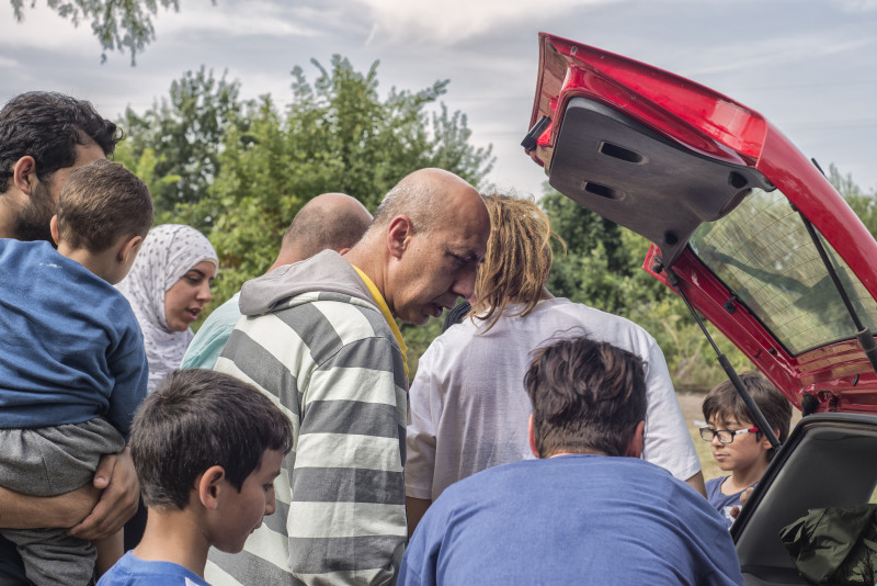 <p>Mahmoud Saad reparte comida entre refugiados sirios en la carretera que une Horgos (Serbia) con el paso fronterizo a Hungría.</p>