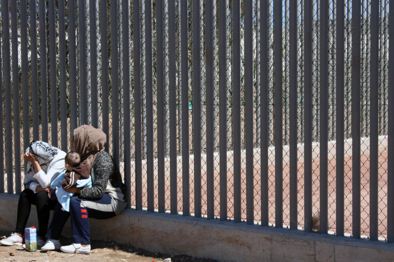 <p>Dos mujeres en la valla exterior del CETI de Melilla.</p>