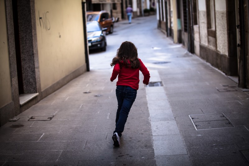 <p>Una niña corriendo por la calle.</p>