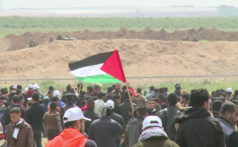 <p>Soldados israelíes observan a manifestantes palestinos, durante las manifestaciones del 30 de marzo donde fueron asesinadas 18 personas por el ejercito de Israel</p>