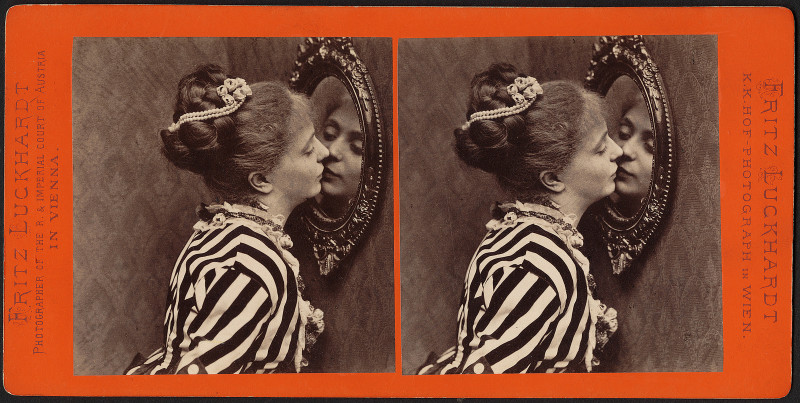 <p>Mujer besando su reflejo en un espejo.</p>