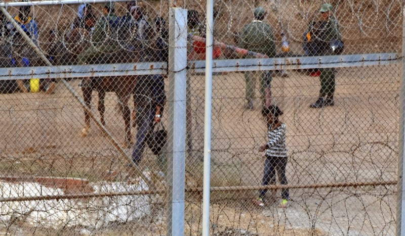 <p>Niña migrante detrás de una valla fronteriza.</p>