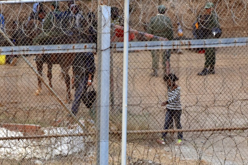<p>Niña migrante detrás de una valla fronteriza.</p>