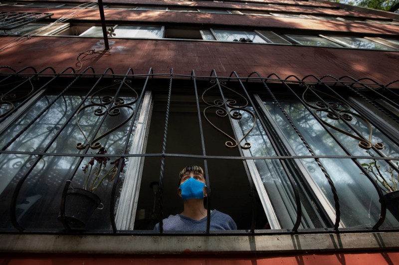 <p>Una mujer mira por la ventana en Ciudad de México.</p>