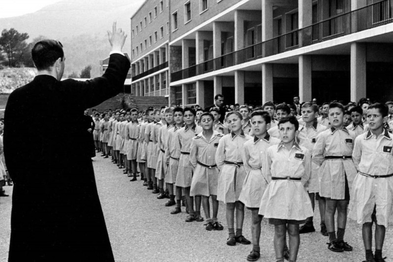 <p>Niños en formación ante un sacerdote. Foto del libro Los internados del miedo. </p>