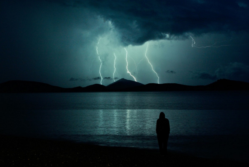 <p>Una persona observa una tormenta lejana. </p>