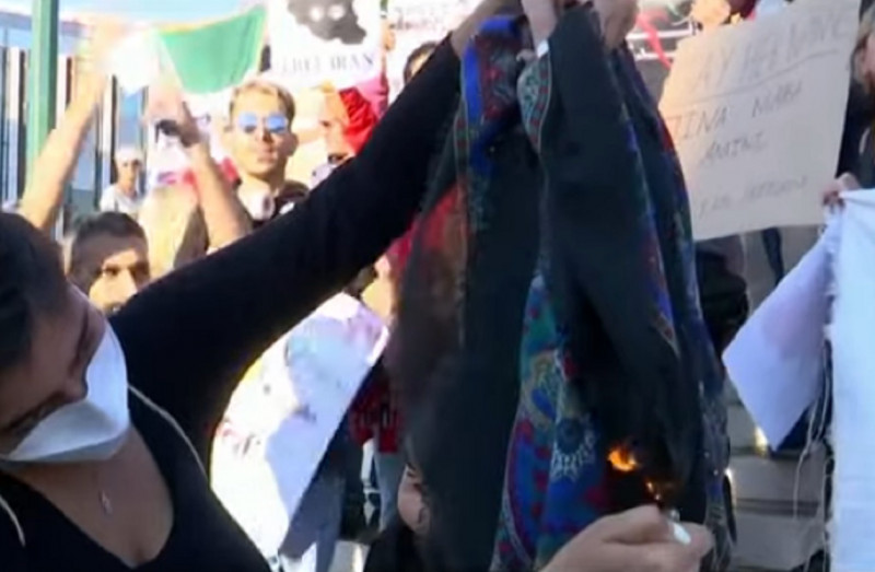 <p>Una mujer prende fuego a un pañuelo en una protesta por la muerte de la joven iraní Mahsa Amini.</p>