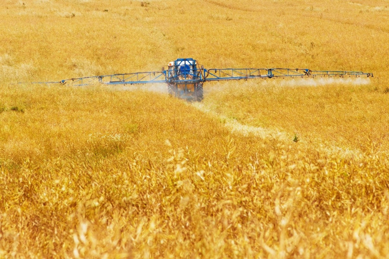 <p>Un tractor rocía productos sobre un cultivo.</p>