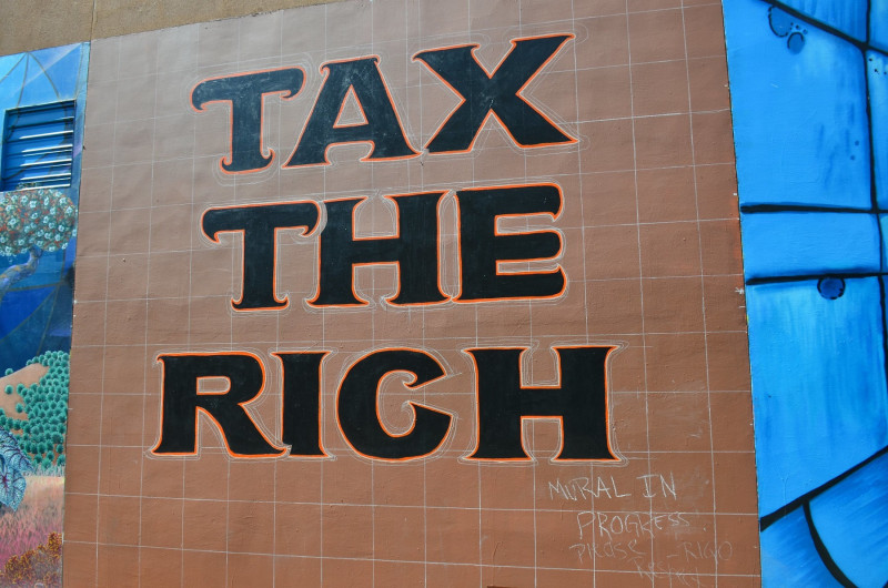 <p>Mural sin terminar con el eslogan ‘Tax the rich’. <strong>/ Steve Rhodes</strong></p>
