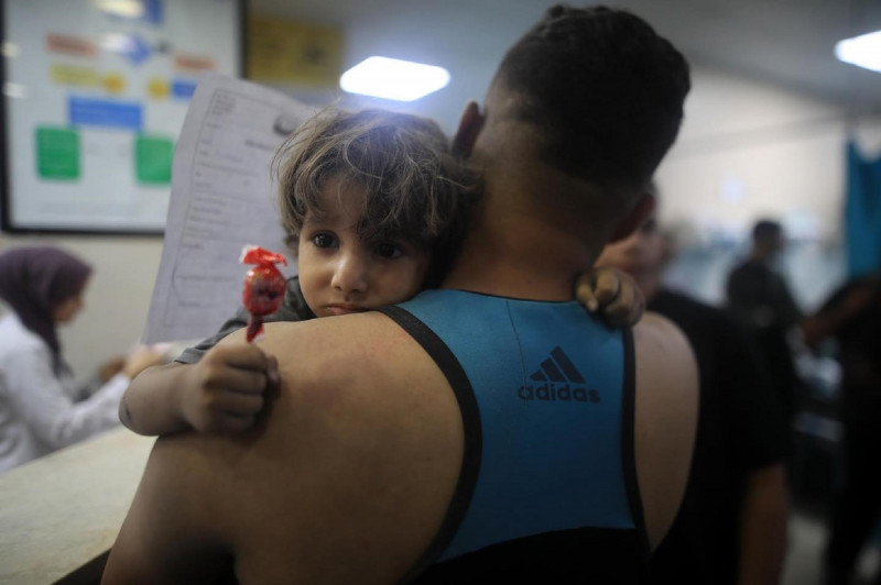 <p>Un niño gazatí abraza a su padre en un hospital de la Franja. / <strong>Mohammed Zannoun</strong></p>