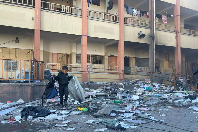 <p>Un niño rebusca entre los restos de un colegio bombardeado en la ciudad de Gaza, el 23 de febrero de 2024. / <strong>M. M.</strong></p>