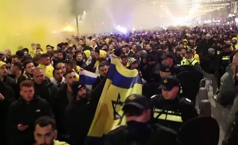 <p>Hooligans del Maccabi de Tel Aviv en Ámsterdam vigilados por la policía. / <strong>Michel van Bergen (Guardian News / Youtube)</strong></p>