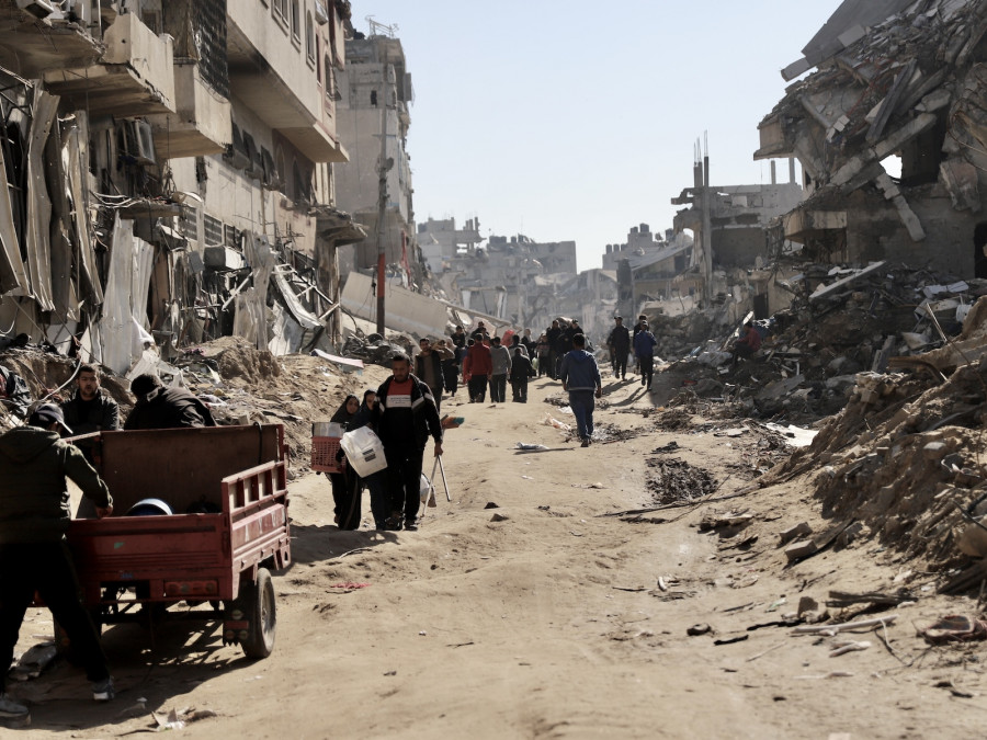 <p>Palestinians walk between the shreds in Shuja'iya, north of Gaza. February 2024. / <strong>Mohammed Hajjar</strong></p>