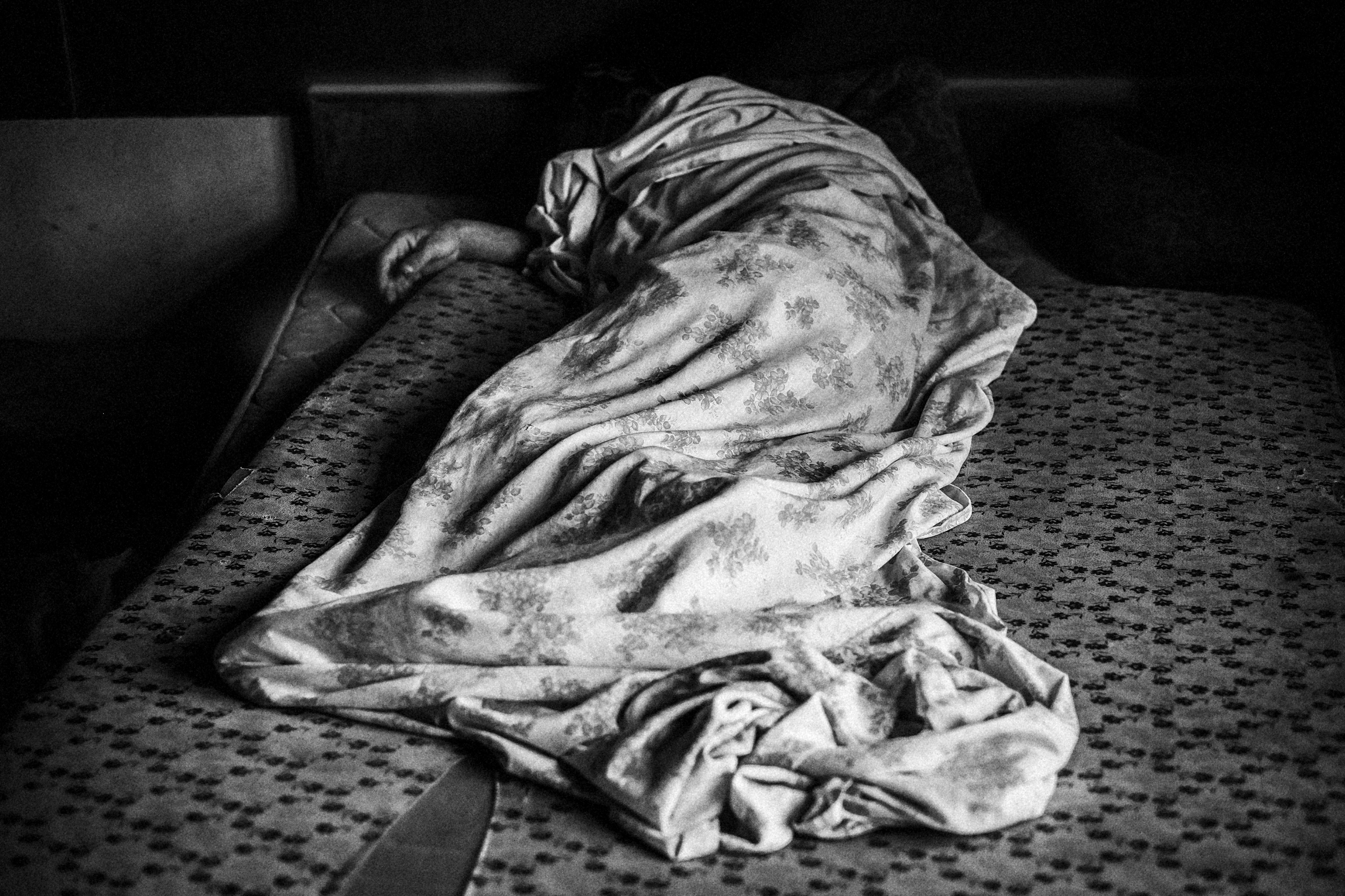 13 de julio de 2014. Vitor, 65 años, duerme en una cama en una fábrica abandonada. Vitor fue invitado a vivir allí por otros residentes de la fábrica cuando le vieron durmiendo en la calle.