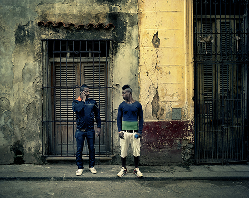 Dos jóvenes esperan a una chica en La Habana Vieja. 