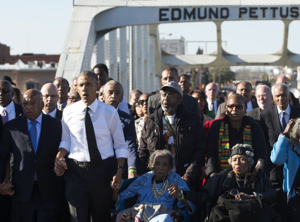 Barack Obama canta acompañado de los manifestantes de la marcha de Selma que cruzaron el puente Edmund Pettus hace 50 años. (SAUL LOEB)