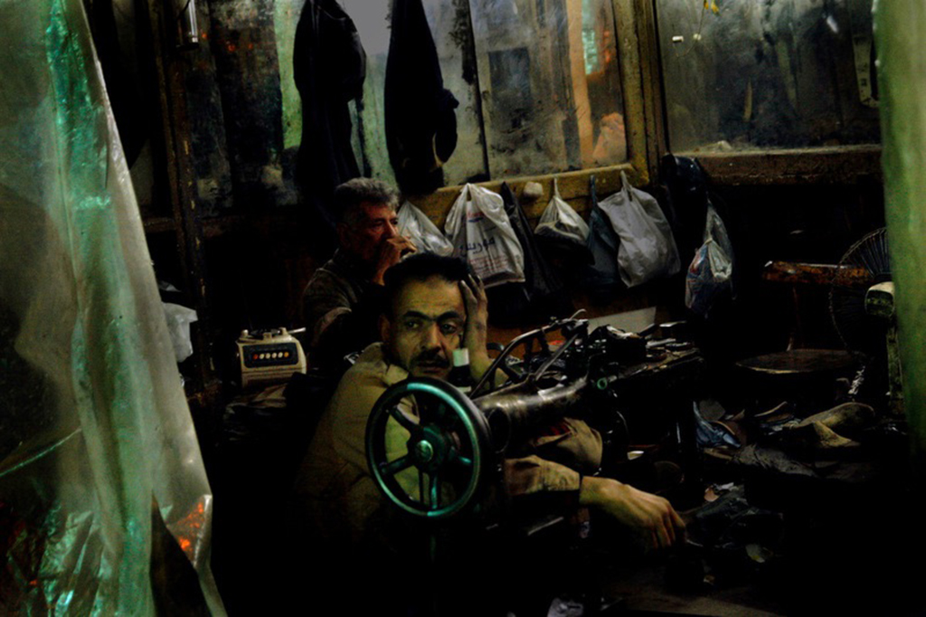 Un zapatero, con gesto de preocupación, descansa en su tienda del barrio El Hussein de El Cairo. Con un altísimo porcentaje de paro, la mayoría de los universitarios acaba la carrera sabiendo que no va a poder dedicarse a aquello para