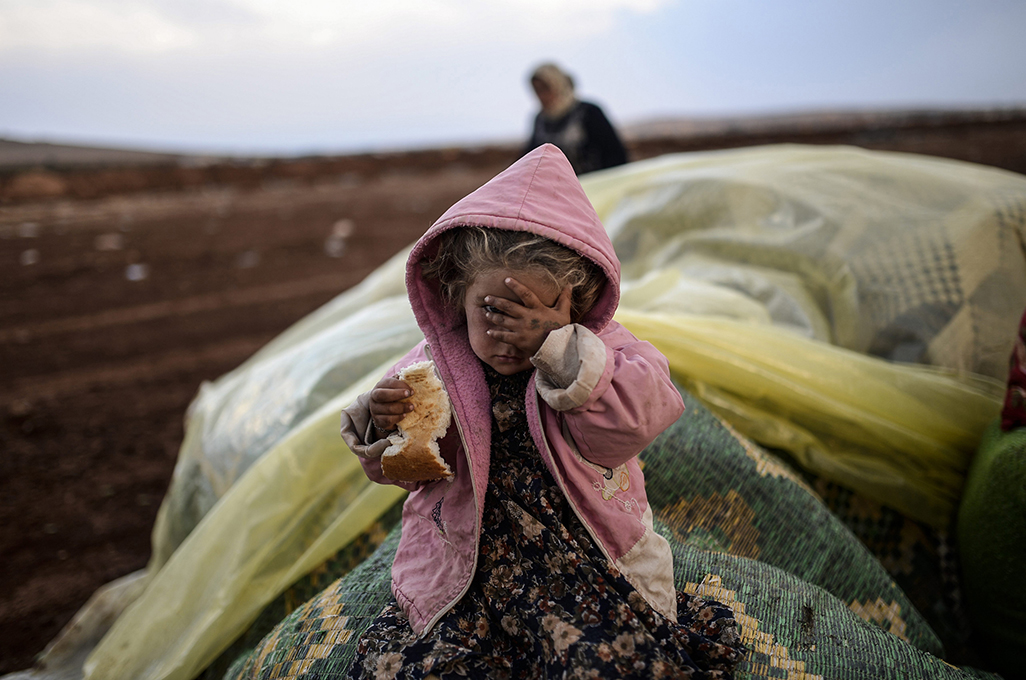 <p>Una mujer kurda y su hija esperan a que cese el fuego  en ambos lados, después de haber cruzado a Turquía desde Siria. © Bülent Kiliç / AFP . Premio Visa de Oro 2015.</p>