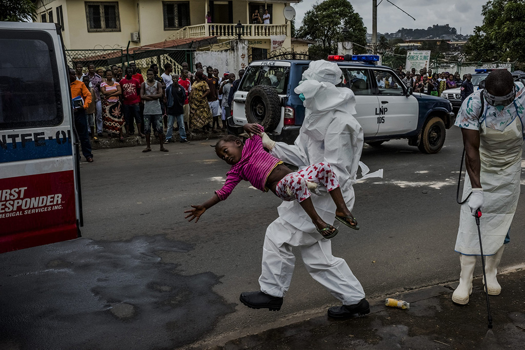 <p>Esther Doryen es trasladada hacia una ambulancia para ser transportada al Centro de Tratamiento de Ebola, dirigido por Médicos sin Fronteras en Monrovia, Liberia, 31 de agosto de 2014. © Daniel Berehulak  para The New York Times / Getty Images Reportage</p>