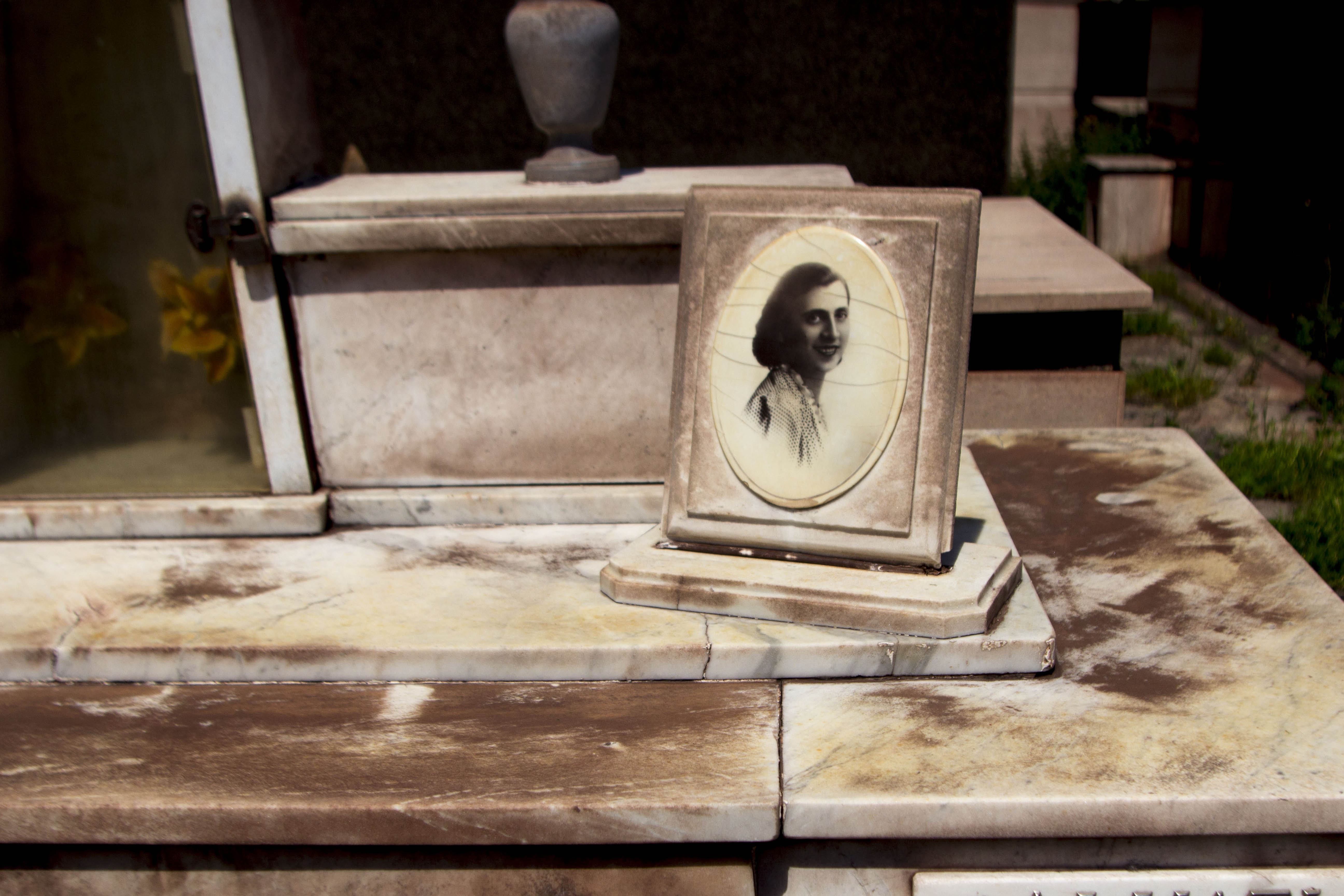 <p>Lápida de mármol blanco manchada por el polvo de óxido rojo en el cementerio.</p>