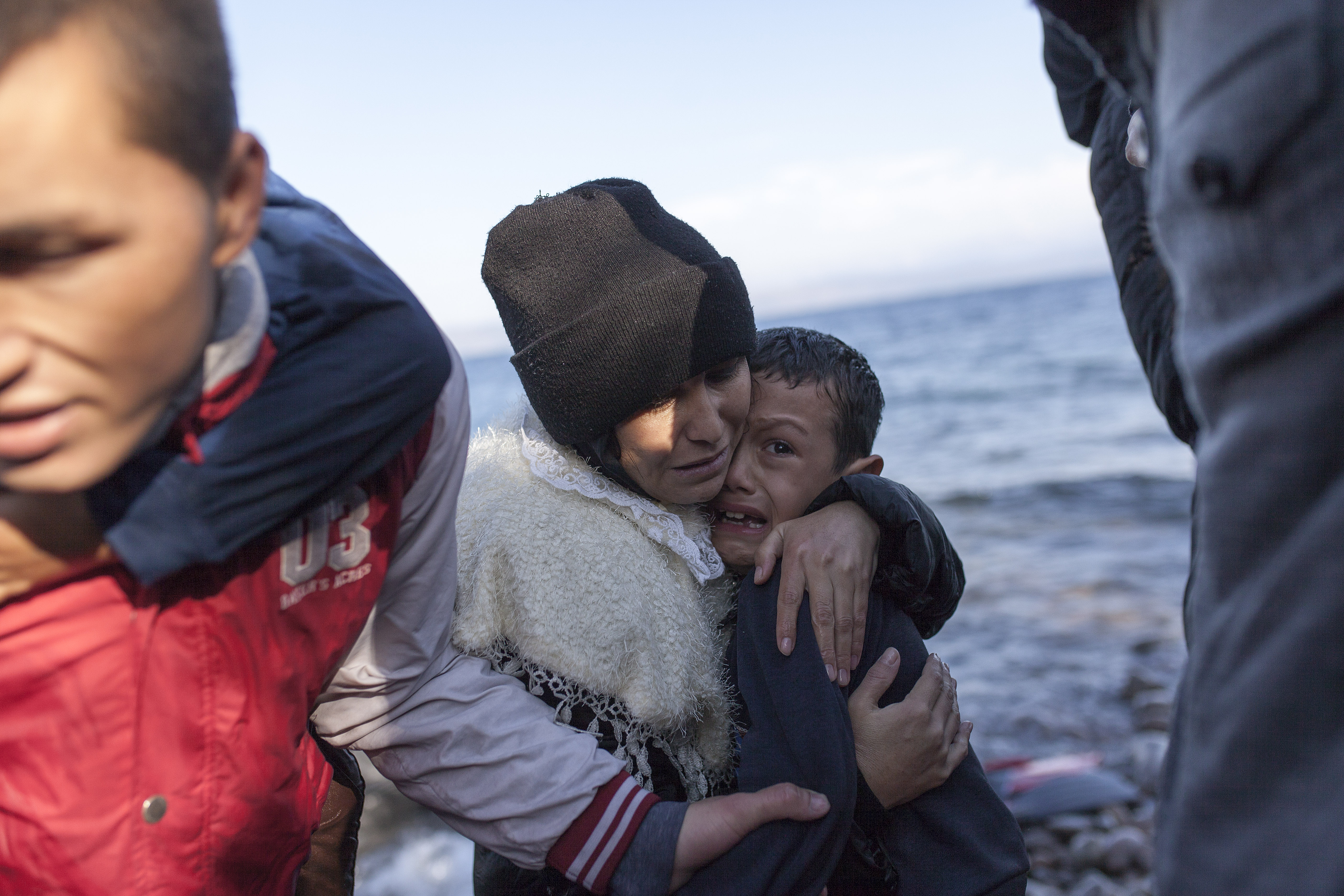 <p>Una madre abraza a su hijo, asustado, tras desembarcar en una playa de Lesbos.</p>