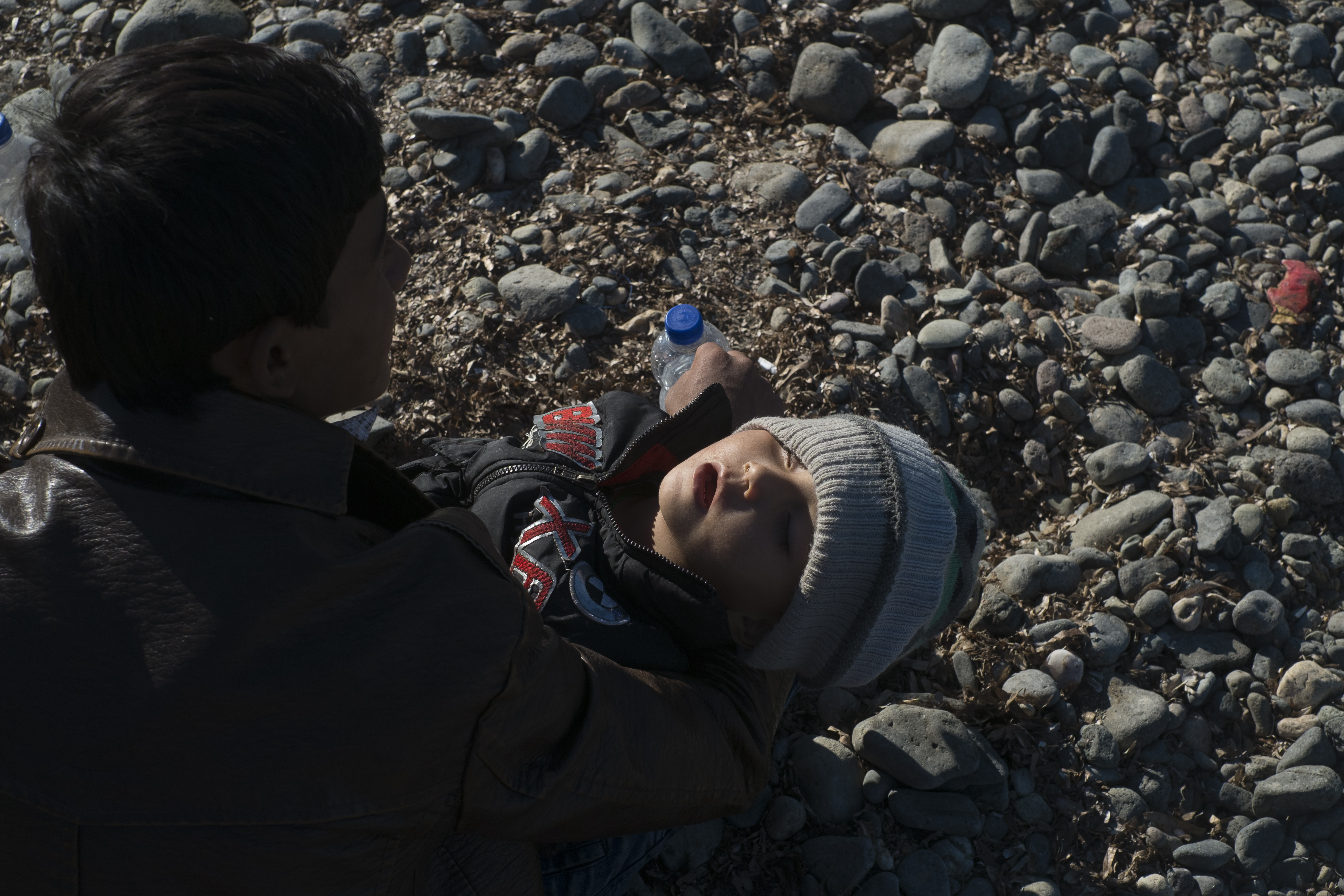 <p>Un padre sostiene a su bebé exhausto tras llegar en una barca hinchable desde Turquía. Las mafias cobran 1.000 euros por persona para subirse en una embarcación de este tipo, 2.000 sin son de madera.</p>