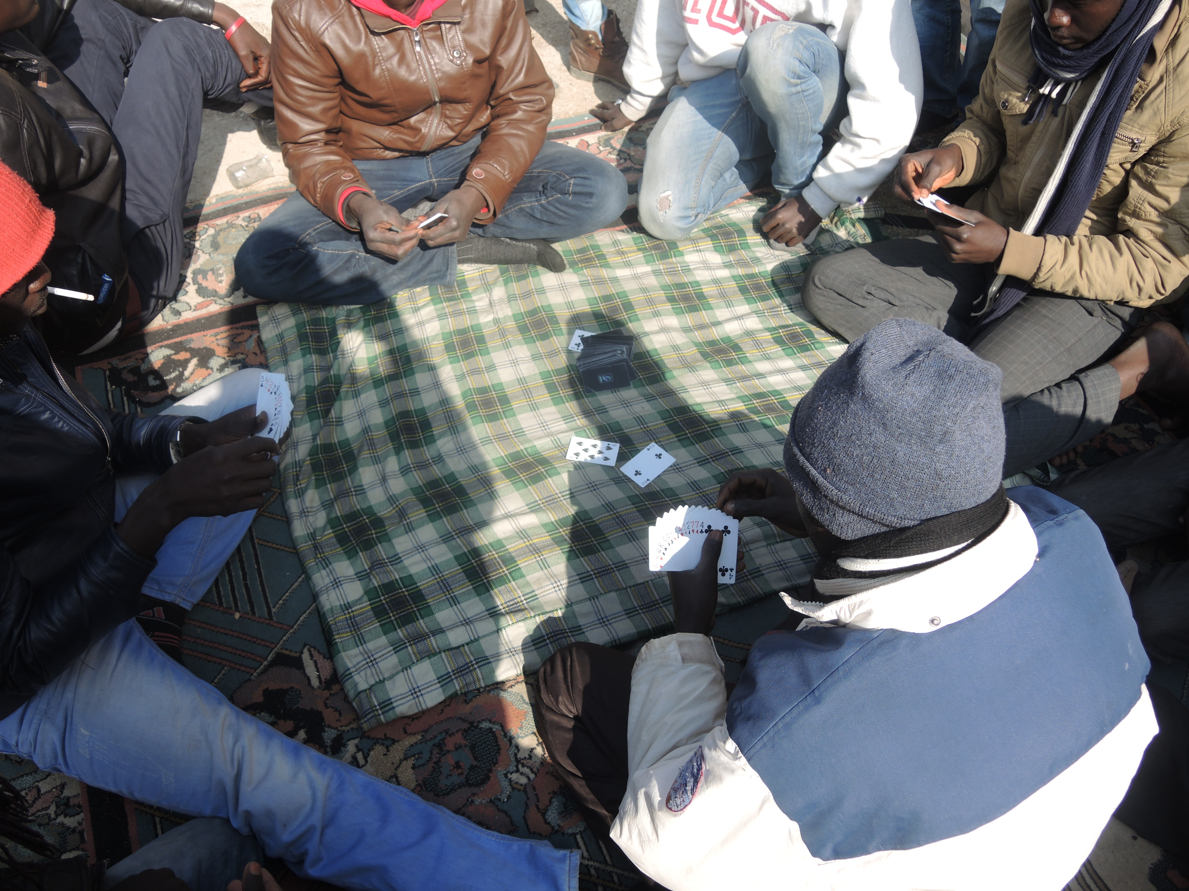 <p>Un grupo de jóvenes juega a las cartas en el campamento.</p>