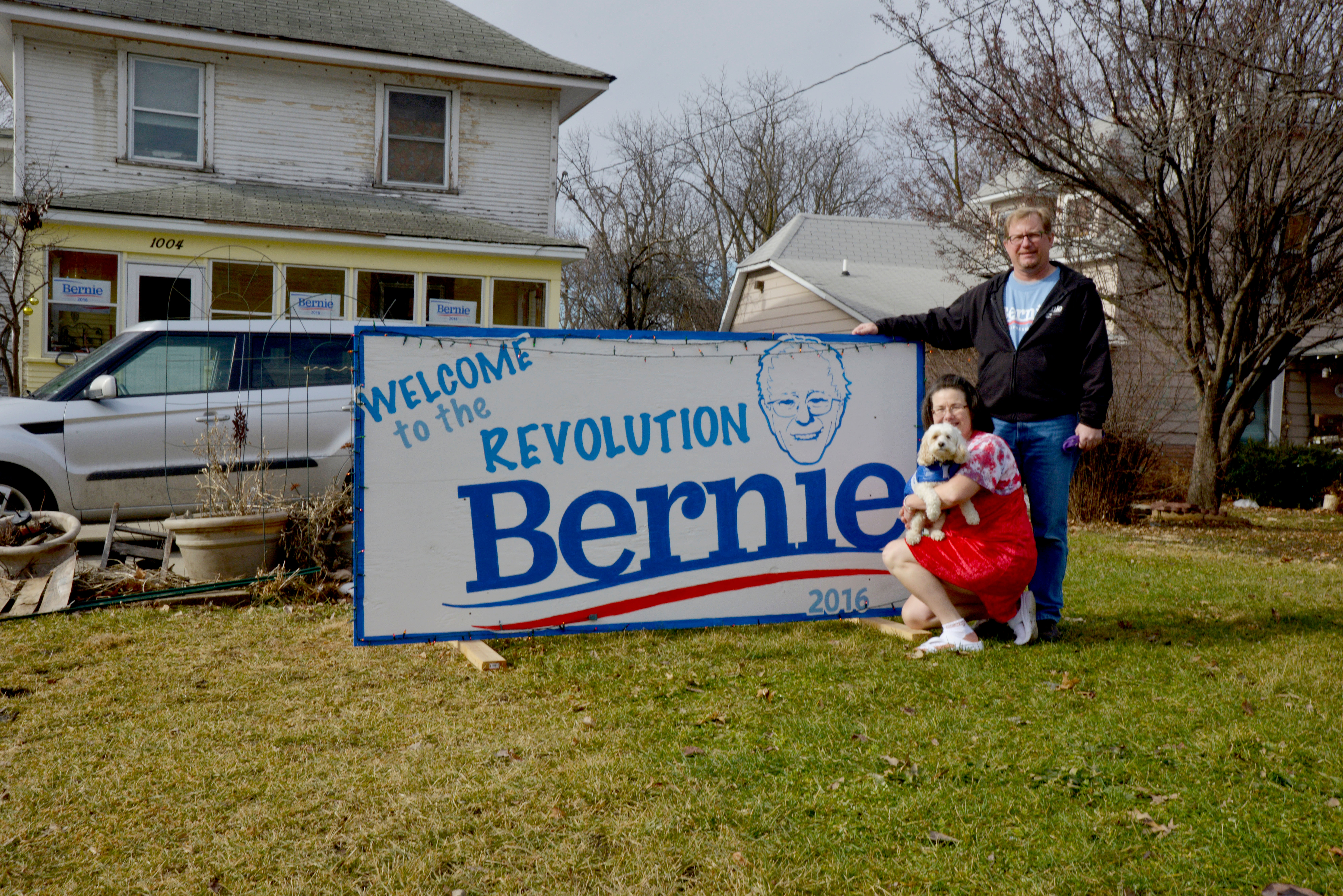 <p>Tim y Kate Schofield posan junto a un cartel a favor de Sanders enfrente de su casa. Tim trabaja en la campaña del candidato demócrata.</p>