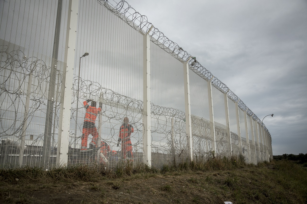 <p>Un grupo de trabajadores estatales repara un sector de la valla que evita el acceso a la carretera, tras un intento de traspasarla por un grupo de migrantes. </p>