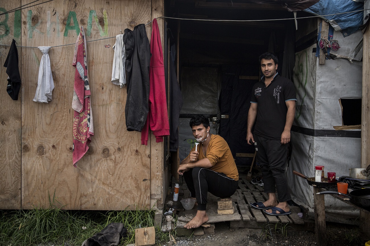 <p>Migrantes afganos a las puertas de su chabola. Afganistán es el segundo país de procedencia de los migrantes y solicitantes de asilo que malviven en Calais. </p>