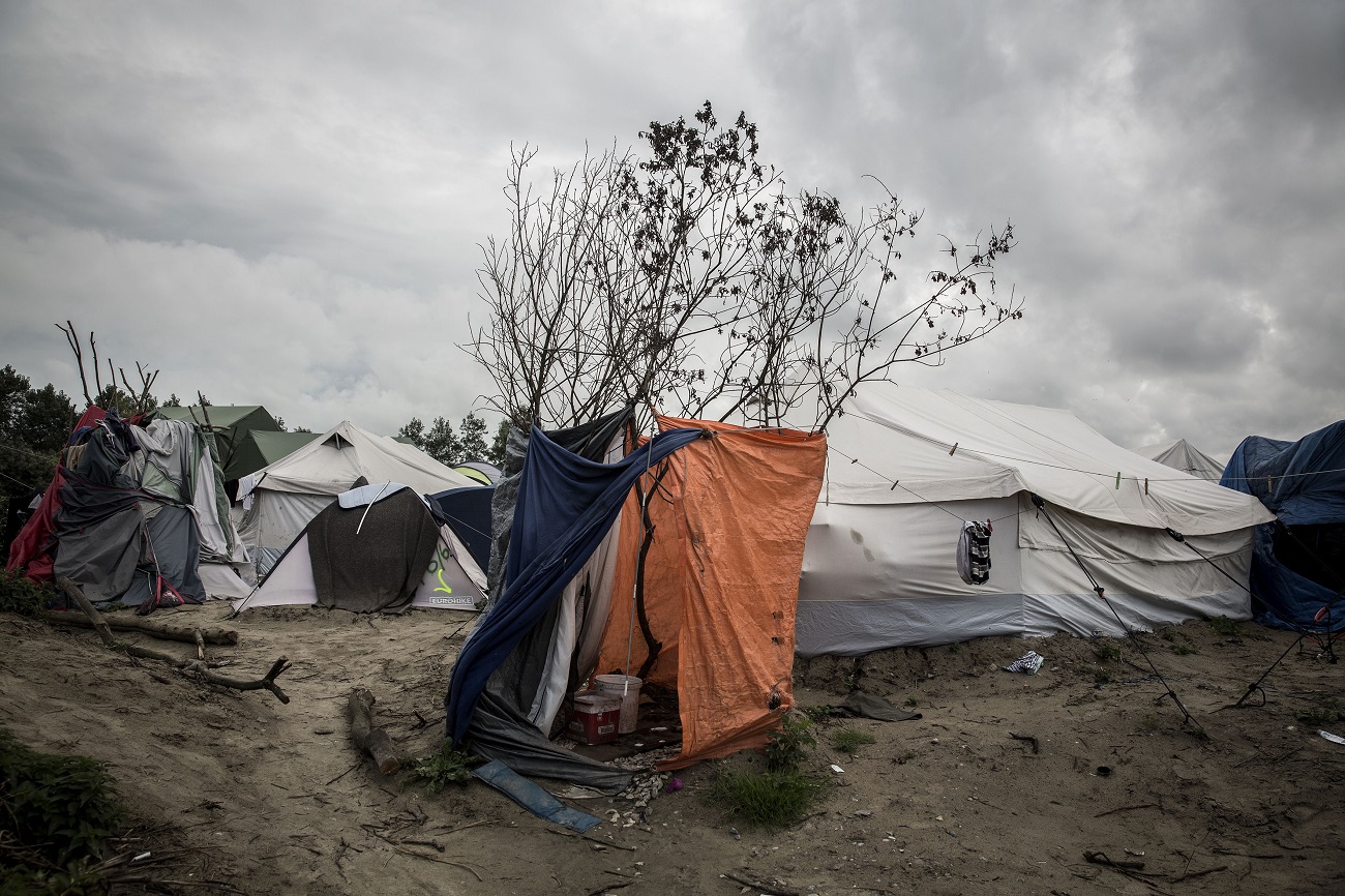 <p>Ante la falta de duchas, los migrantes improvisan espacios para lavarse usando árboles y plásticos. </p>