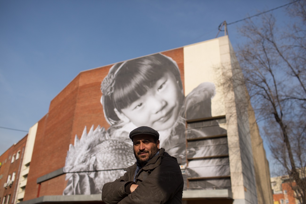 <p>Juan Carlos Toro, ante el mural que cuelga del CDN en Almendrales</p>