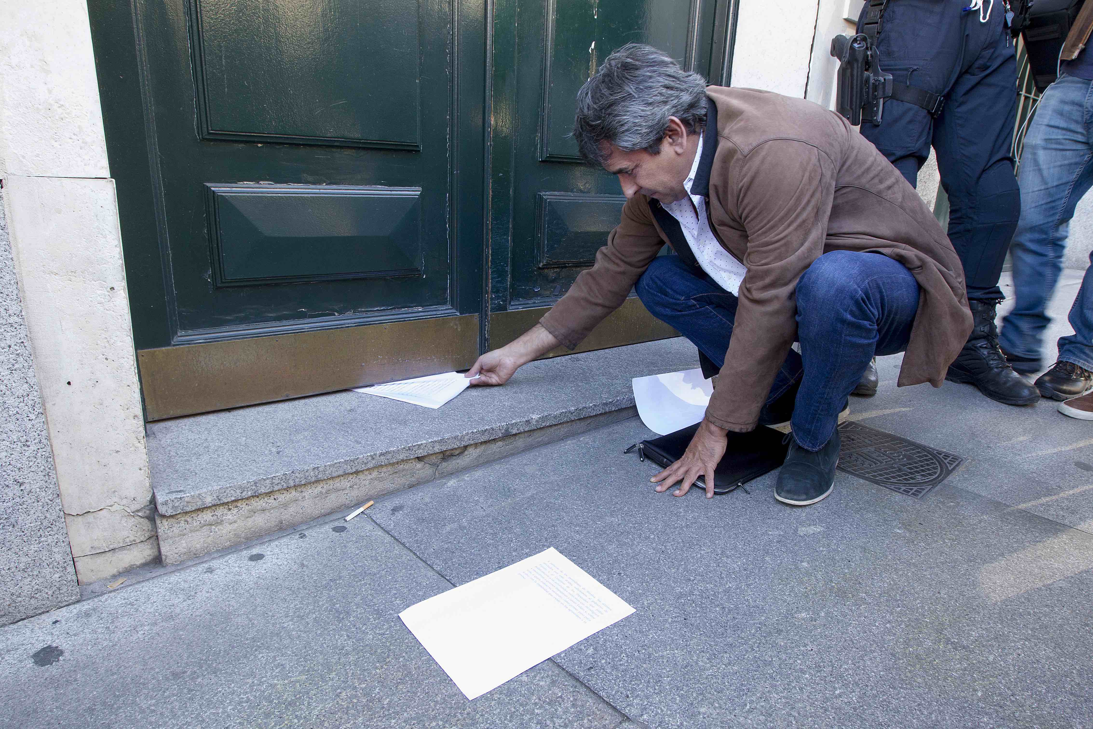 <p>El director de CTXT, Miguel Mora, introduciendo el comunicado bajo la puerta de la Embajada de México.</p>