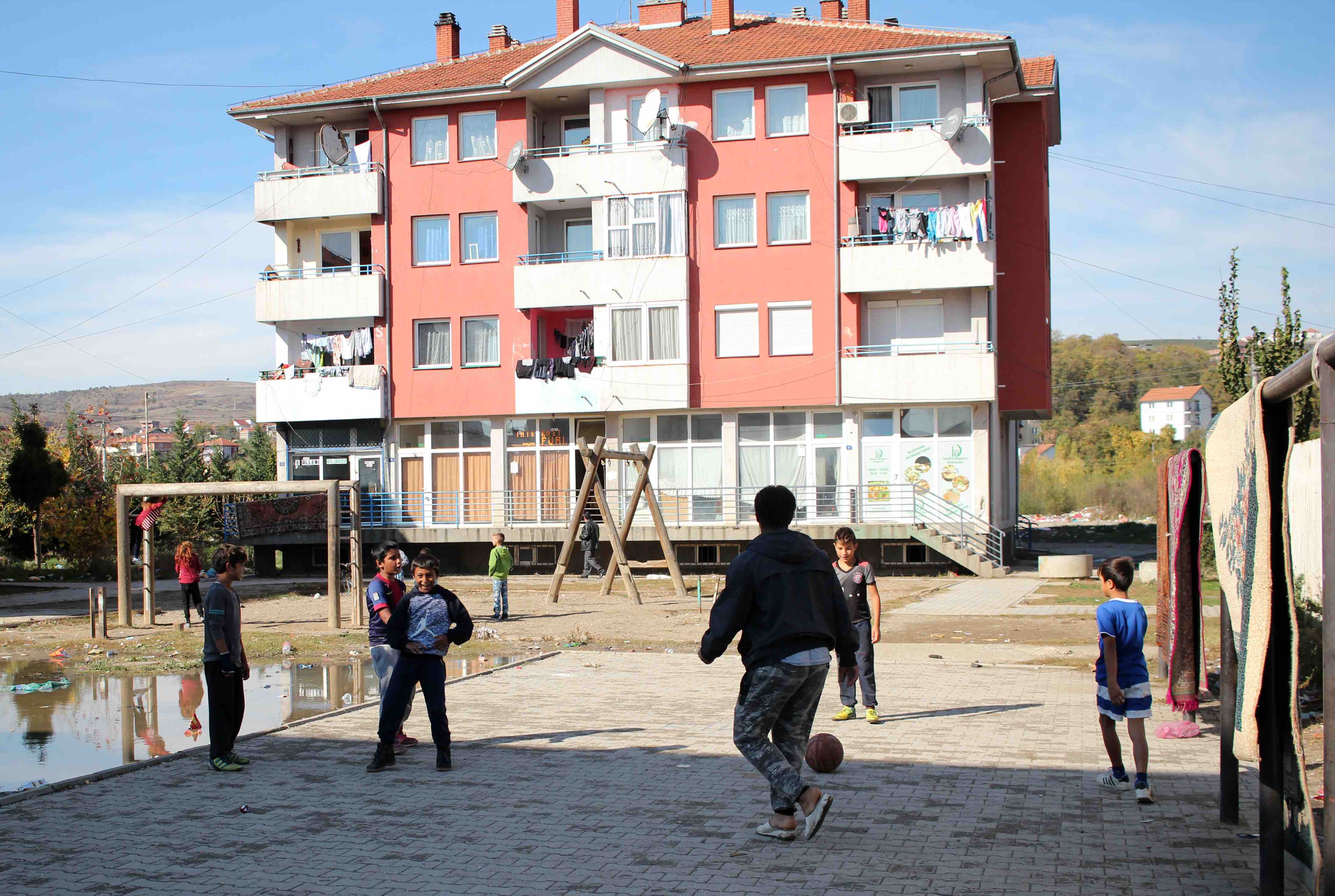 <p>Niños y niñas romaníes juegan en un parque del barrio de Mahalla de Mitrovicë</p>