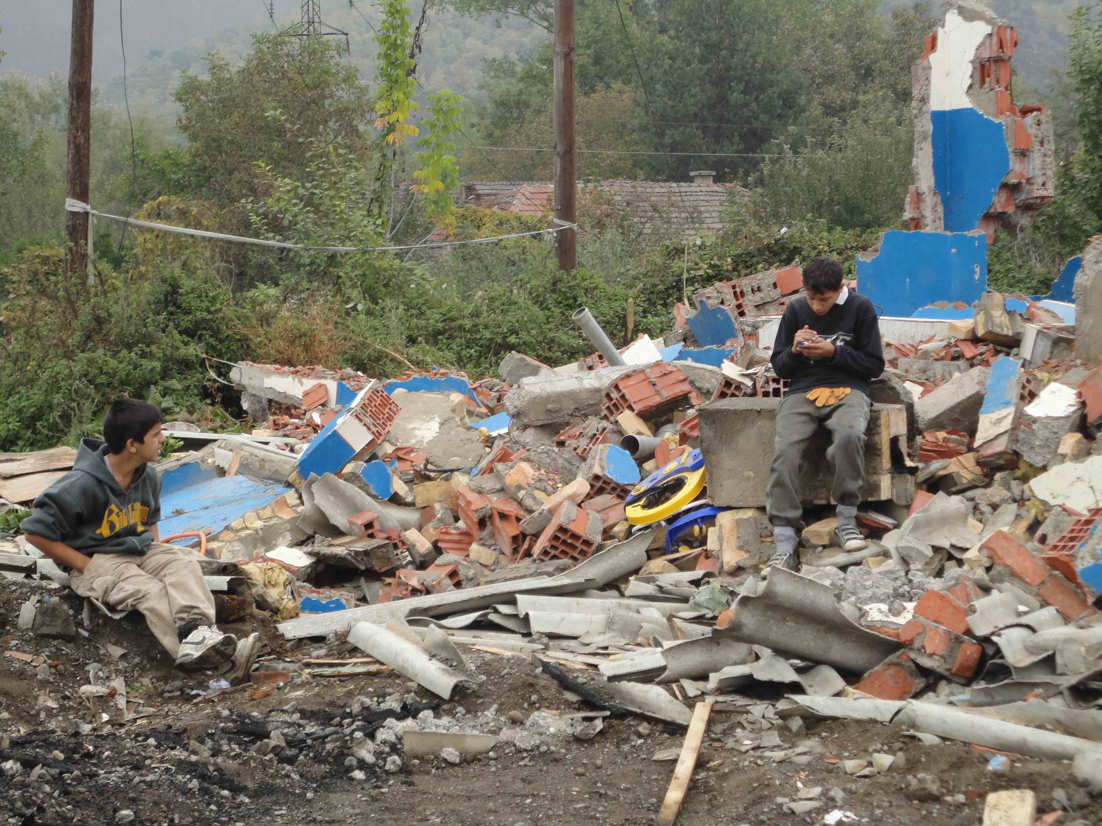 <p>Niños romaníes se toman un descanso tras buscar material que reutilizar en el campo de Cesmin Lug.</p>