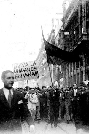 <p>José Antonio Primo de Rivera, al frente de una manifestación contra 'los separatistas catalanes', en la Puerta del Sol (Madrid), el 7 de octubre de 1934. El líder de Falange camina detrás del abanderado.</p>