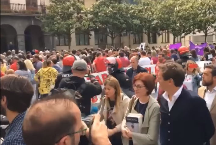 <p>Albert Rivera pasa frente a un grupo de vecinos de Ugao de espaldas a él.</p>